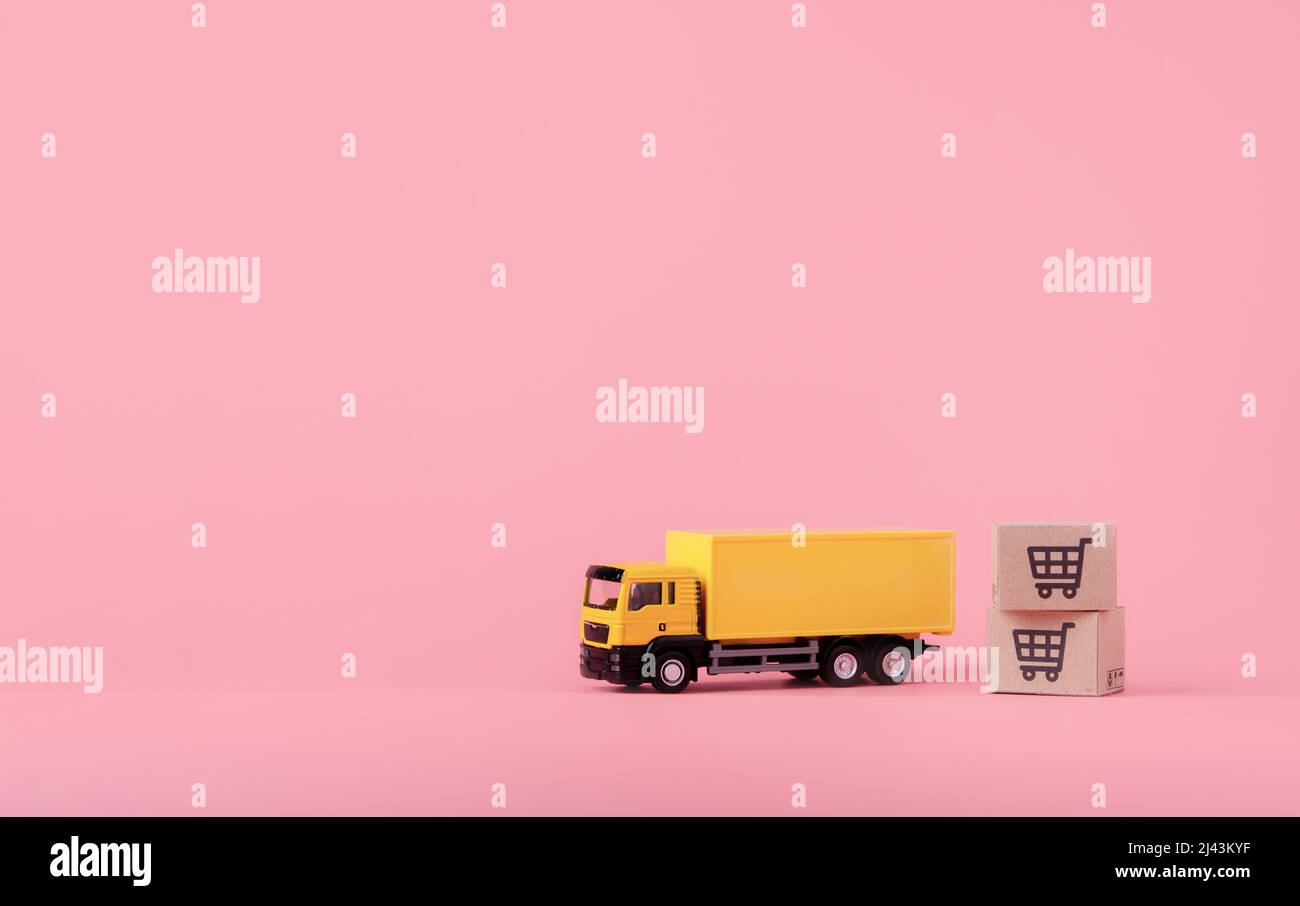 Logistica, e servizio di consegna - camion del carico e cartoni o pacchi di carta con un logo del carrello della spesa su sfondo rosa. Servizio di shopping on-line Foto Stock