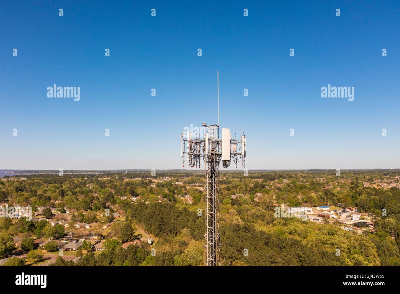 La torre di comunicazione del telefono cellulare contro il cielo blu. Foto Stock