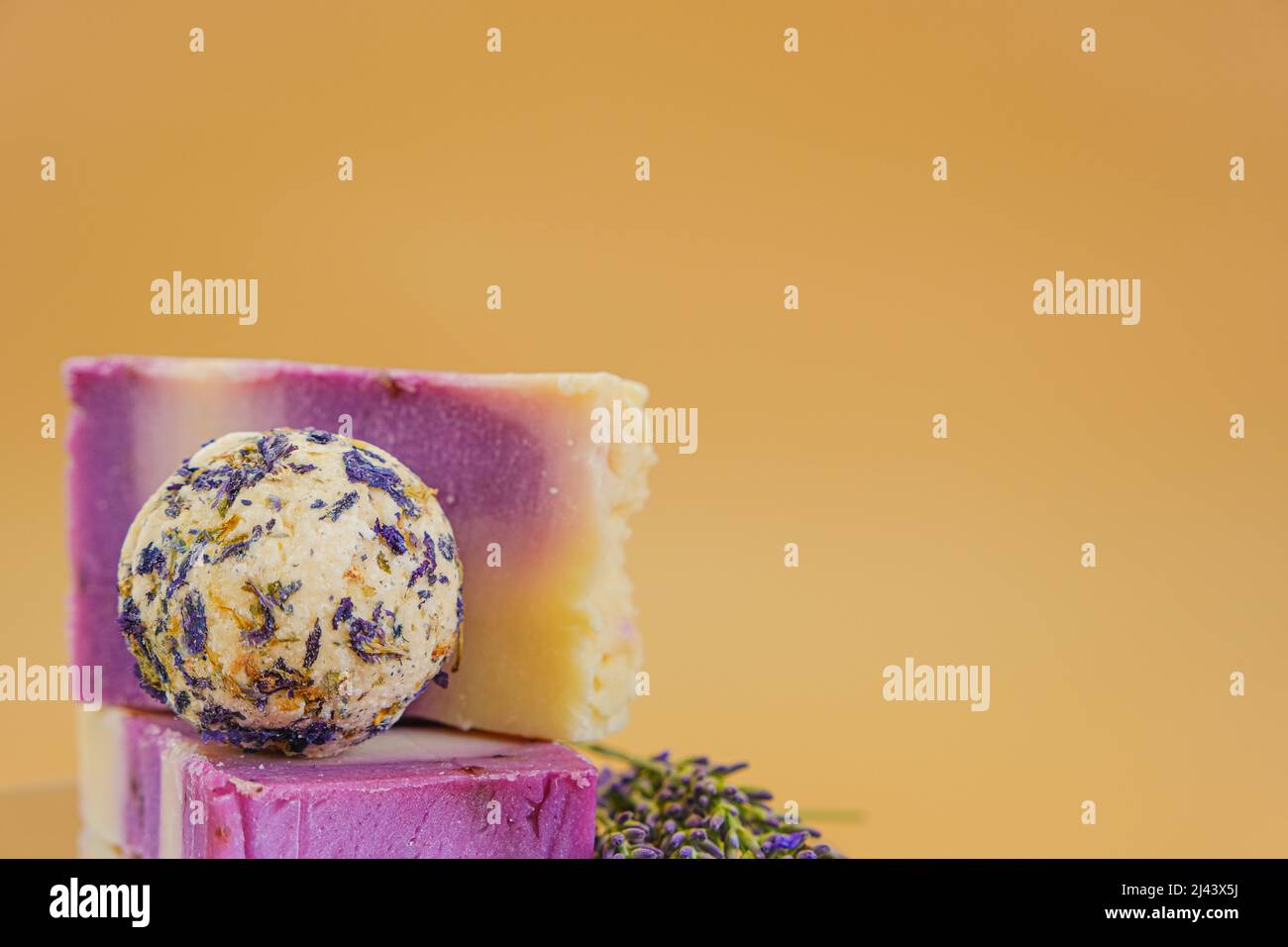 Sapone alla lavanda. Saponette e tartufi per il corpo con petali di lavanda su sfondo beige. Aromaterapia e spa con estratto di lavanda. Corpo Foto Stock