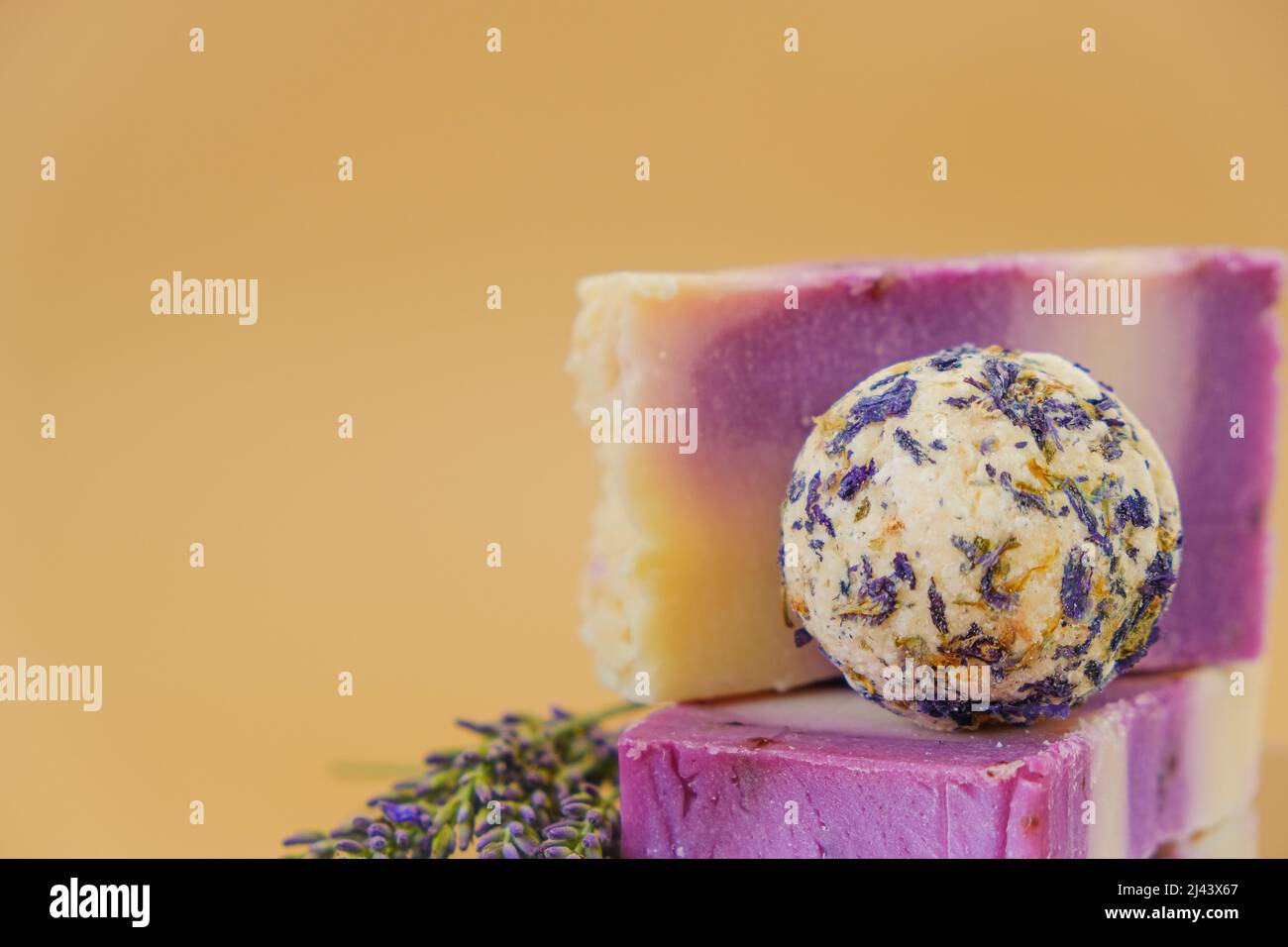 Sapone alla lavanda. Saponette e tartufi per il corpo con petali di lavanda su sfondo beige. Aromaterapia e spa con estratto di lavanda. Corpo Foto Stock