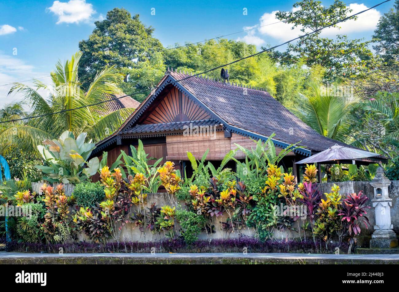 Splendida vista della villa di Bali, architettura tradizionale balinese e paesaggio di piante tropicali con cielo blu e sfondo di nuvole sparse in Indonesi Foto Stock