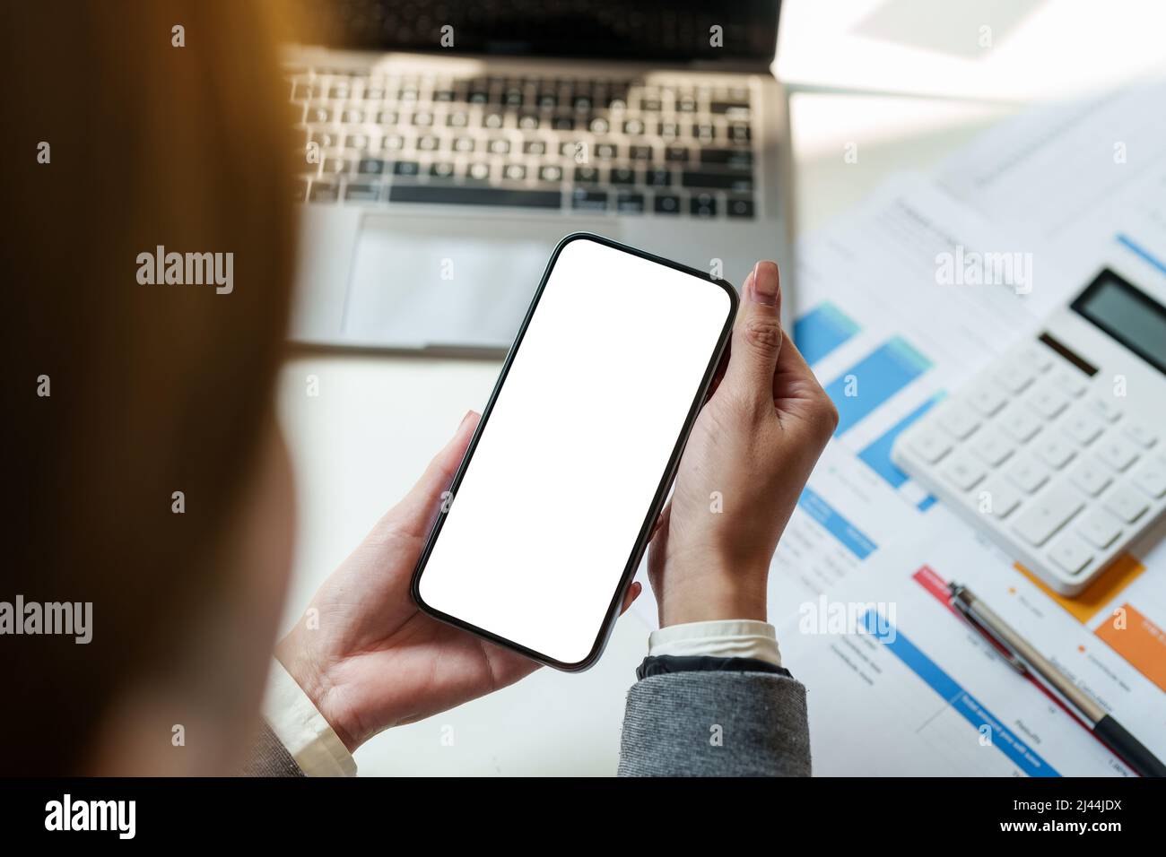 Vista scattata ritagliata delle mani femminili che tengono lo smartphone con schermata vuota dello spazio di copia per i messaggi di testo o i contenuti informativi. Foto Stock