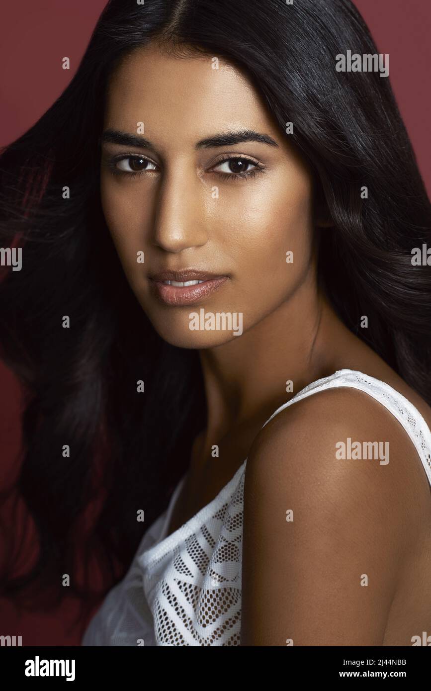 Puramente bella. Primo piano ritratto di una bella donna indiana su sfondo rosso. Foto Stock