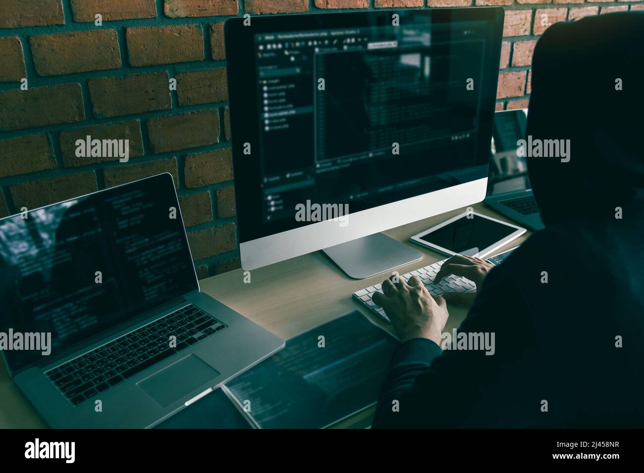 Hacker in the Hood lavorare con il computer con hacking che si rompono in server di dati. Foto Stock