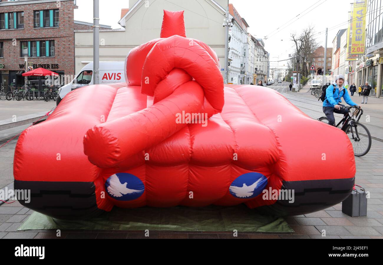 Schwerin, Germania. 12th Apr 2022. Durante il 'Peace Tour' del partito di sinistra, un grande serbatoio gonfiabile con un cilindro annodato pistola si erge su Marienplatz. Il gruppo parlamentare del partito di sinistra ha iniziato la sua tournée in nove stati tedeschi nel Meclemburgo-Pomerania occidentale. Credit: Bernd Wüstneck/dpa/Alamy Live News Foto Stock