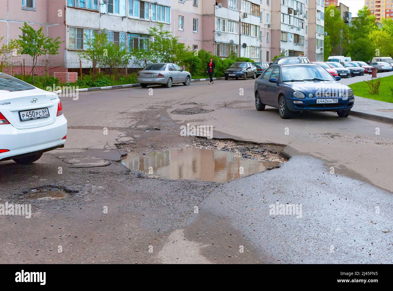 Una fossa nel mezzo della strada nel cortile di un edificio residenziale Foto Stock