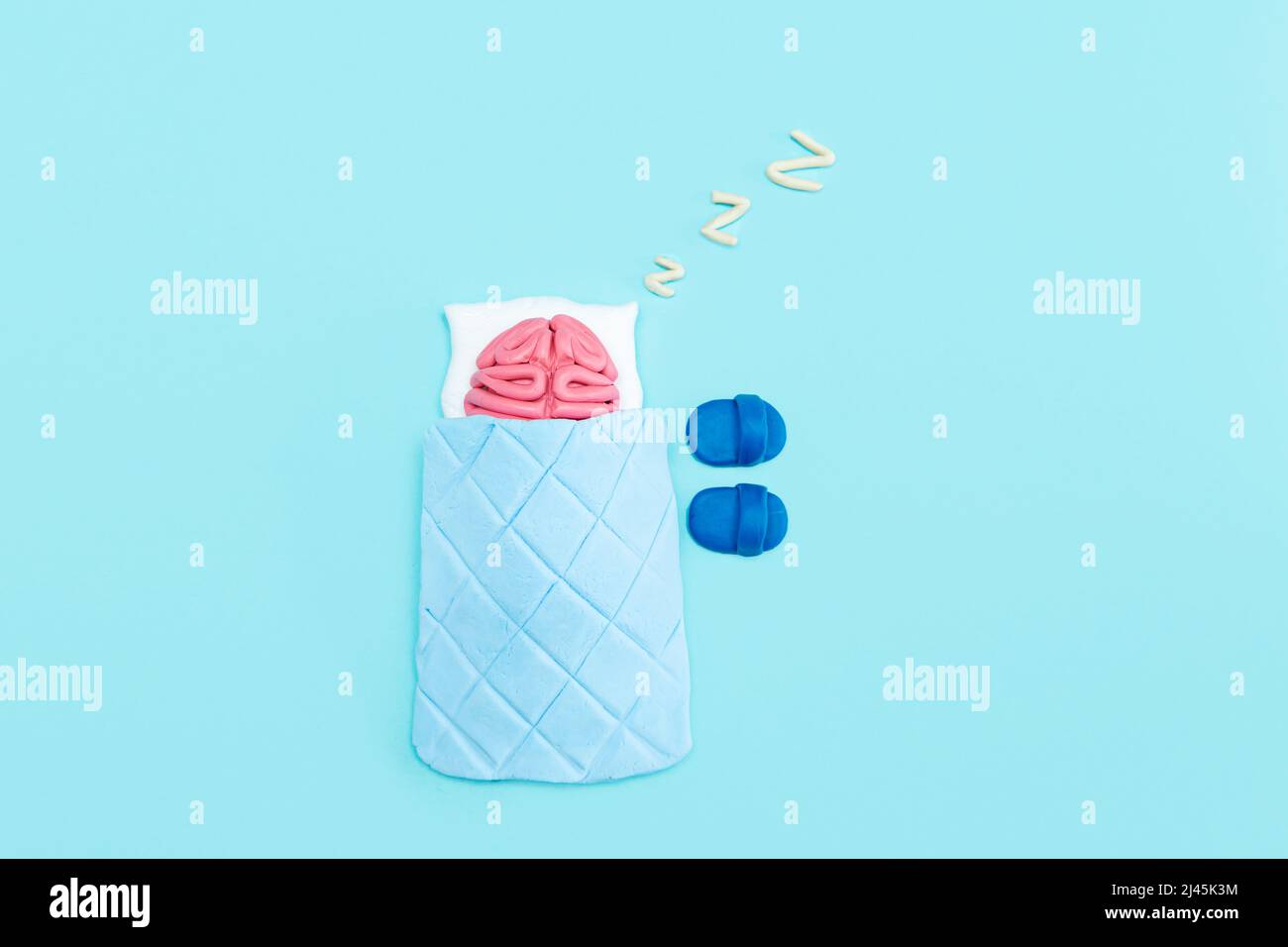Il cervello umano rosa della plastilina sta dormendo. Concetto di riposo mentale. Sfondo blu. Foto Stock