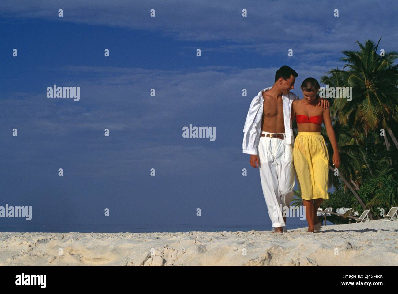 Maldive. Giovane coppia che cammina sulla spiaggia tropicale. Foto Stock