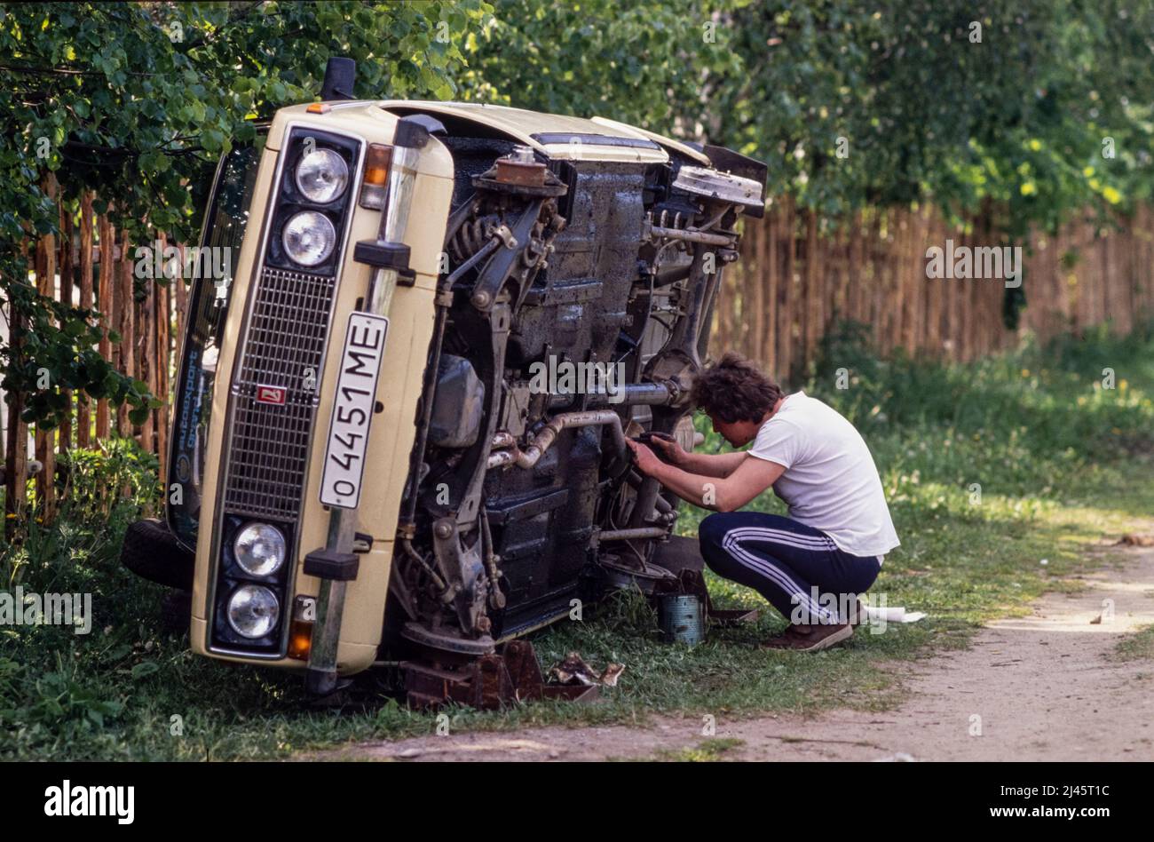 Un uomo che lavora sulla sua macchina Lada, nella città di Sergiyev Posad, a 70 km da Mosca. Foto Stock
