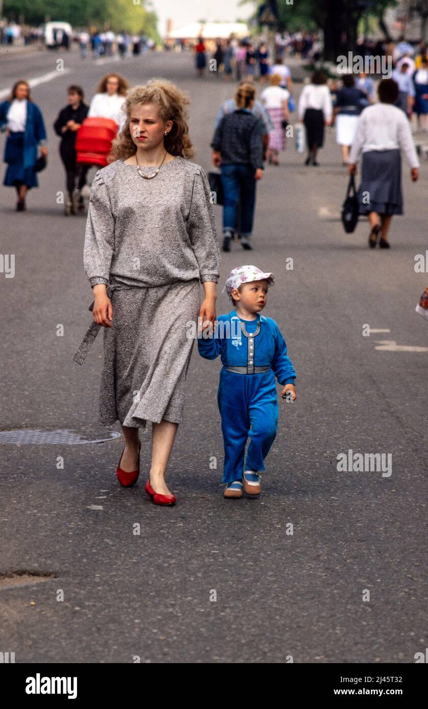 Una madre e suo figlio camminano in una strada pedonale vicino alla Lavra Trinità di San Sergio, il più importante monastero russo della Chiesa ortodossa russa, a Sergiyev Posad, a 70 km da Mosca. Foto Stock