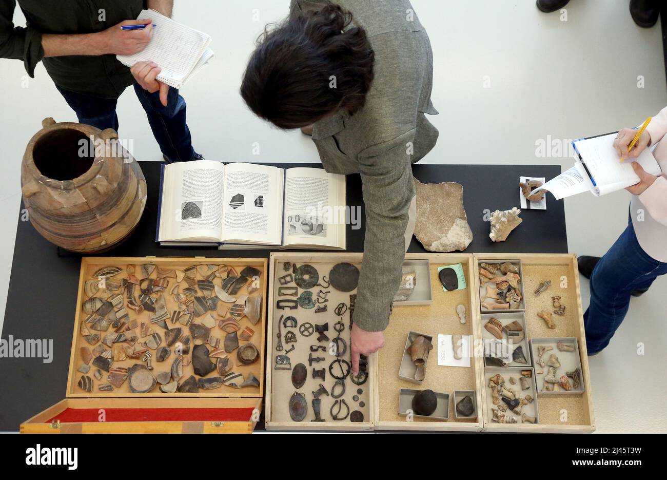 Berlino, Germania. 12th Apr 2022. Durante una conferenza stampa tenuta dal Museo della Preistoria e della Storia Antica, la gente guarda le schegge di brocche rotte e altri oggetti recuperati sul ritorno di oggetti d'arte dalle rovine della seconda Guerra Mondiale del Museo delle Arti Decorative, ora il Gropius Bau. Il museo prevede di presentare alcuni degli oggetti, descritti come 'spectacular', per un totale di circa 1.500. La vedova dell'uomo che tenne gli oggetti nella sua casa aveva contattato il museo. Credit: Wolfgang Kumm/dpa/Alamy Live News Foto Stock