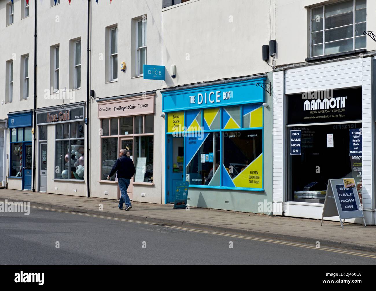 Uomo che cammina accanto al Dice Box gioco caffè, Regent Street, Leamington Spa, Warwickshire, Inghilterra Regno Unito Foto Stock