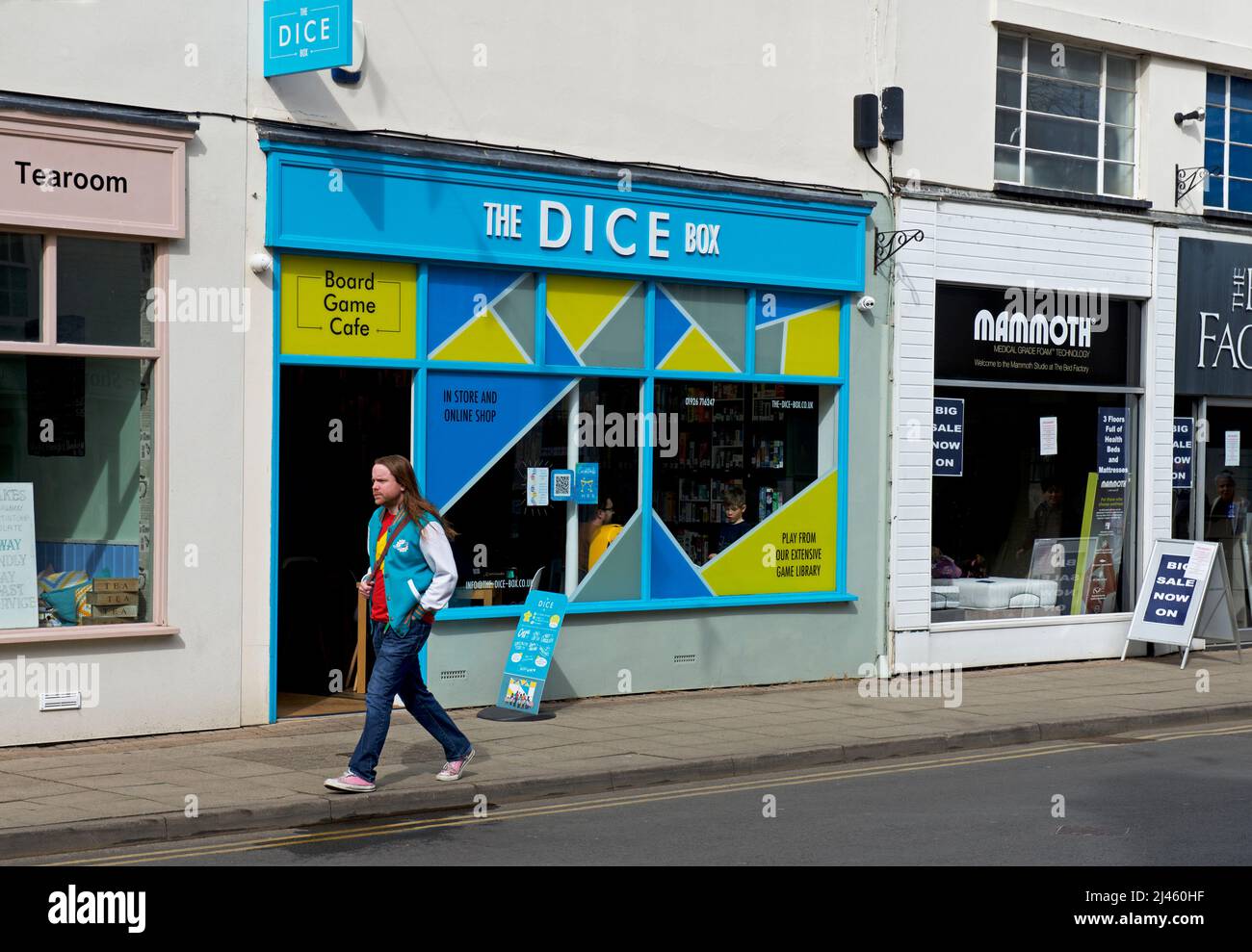Uomo che cammina accanto al Dice Box gioco caffè, Regent Street, Leamington Spa, Warwickshire, Inghilterra Regno Unito Foto Stock