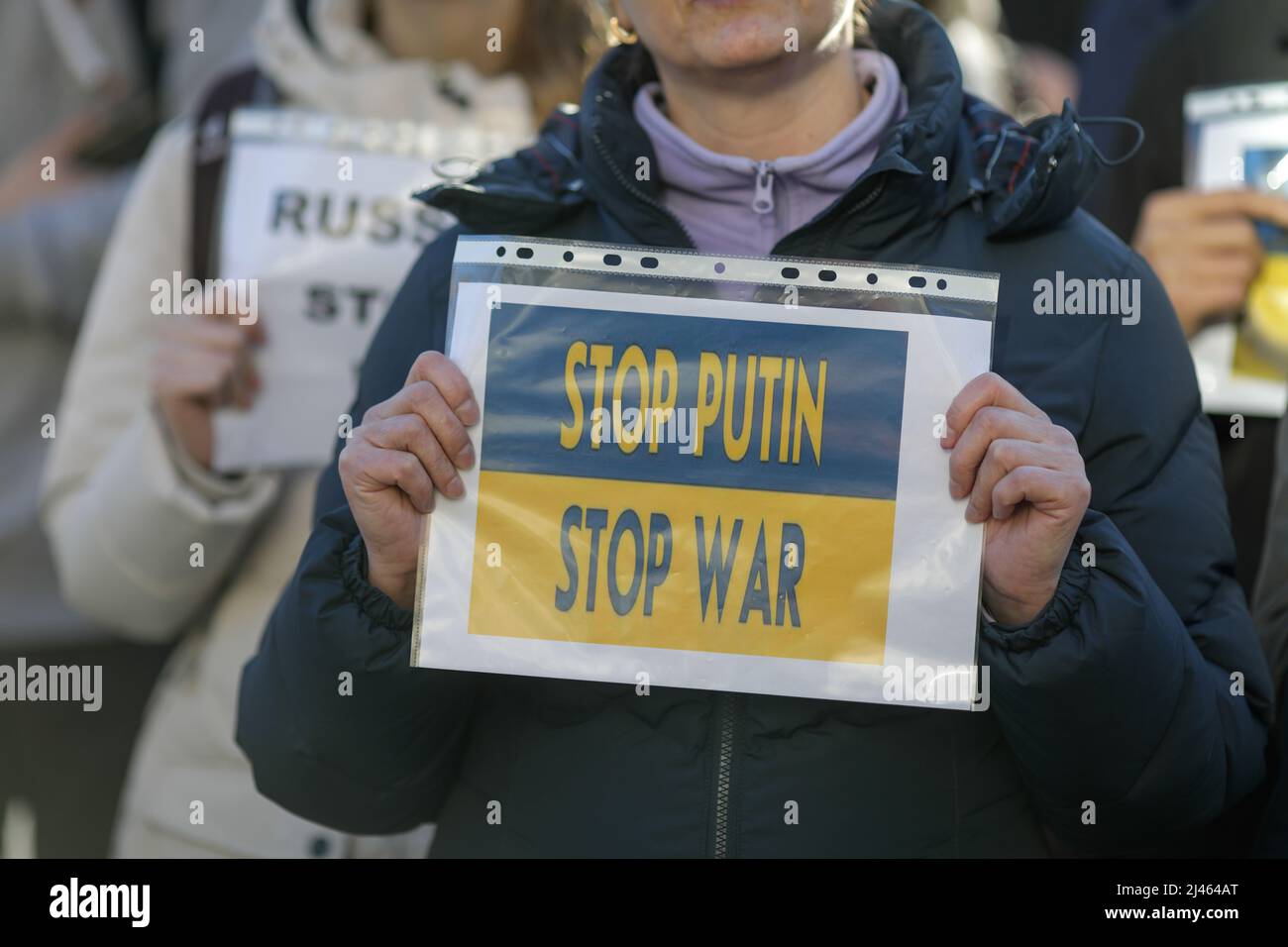 Dettagli con le mani di una donna Ucraina in possesso di una bandiera anti-guerra, pro Ucraina e anti Russia durante una protesta anti-guerra a Bucarest, Romania. Foto Stock