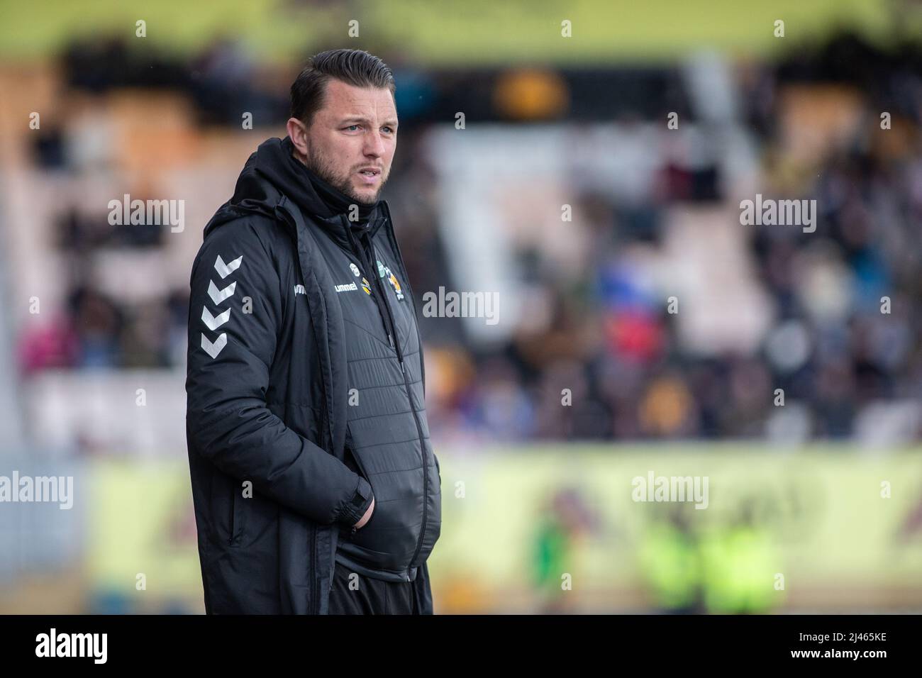 Il manager di calcio Mark Bonner si è levato in piedi sul campo durante la partita al Cambridge United FC, Abbey Stadium, Cambridge, Regno Unito Foto Stock