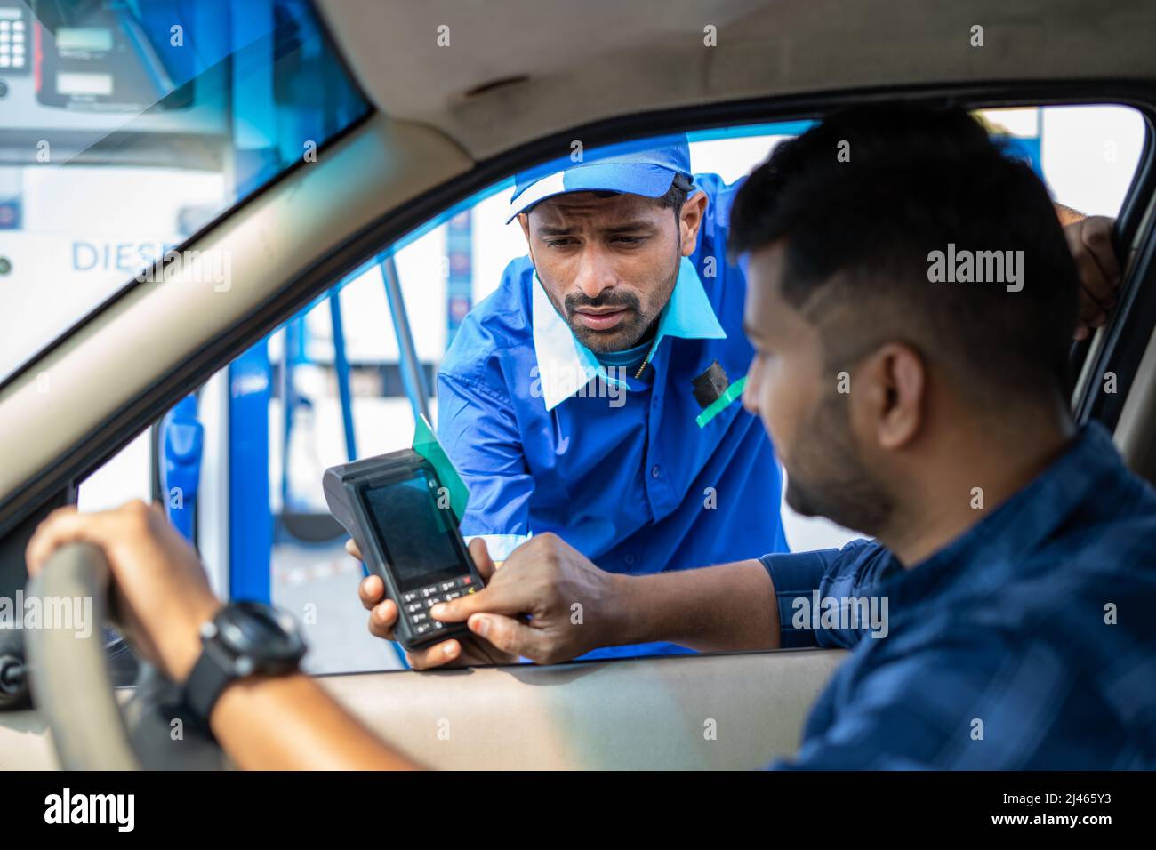 Cliente che paga con carta di credito presso la stazione di rifornimento di benzina facendo scorrere per il rifornimento auto - concetto di cassa digitale payemt, transazione sicura e. Foto Stock