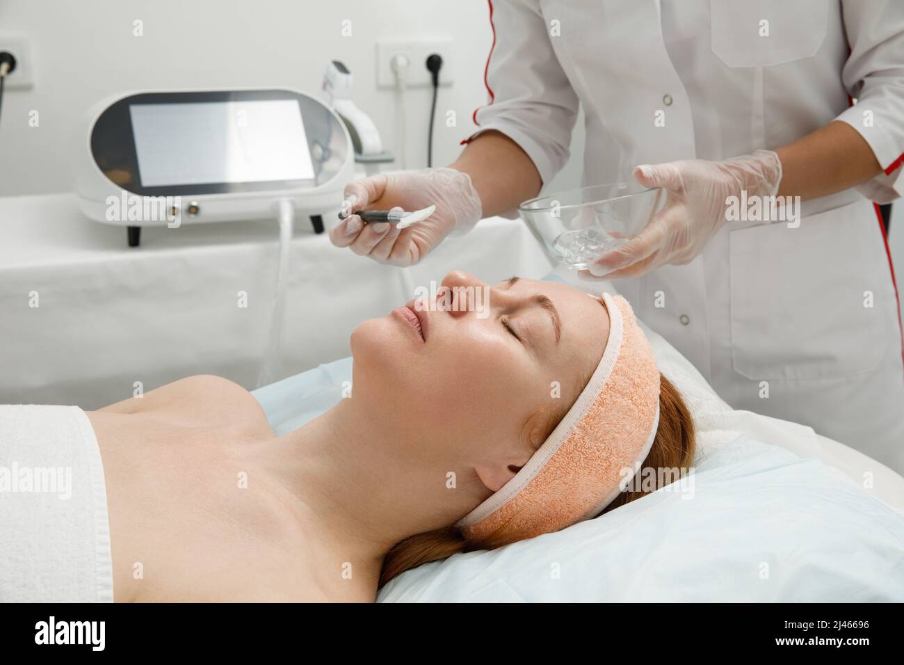 Una donna riceve il trattamento laser del viso in una clinica cosmetologica, un concetto di ringiovanimento della pelle è in fase di sviluppo. Laser peeling Foto Stock