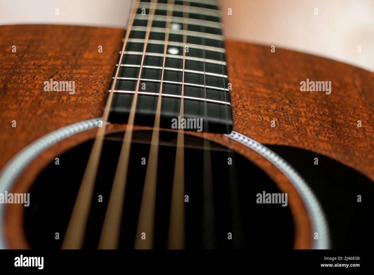 Primo piano, ripresa dall'angolo basso di una chitarra marrone scuro che guarda verso il collo Foto Stock