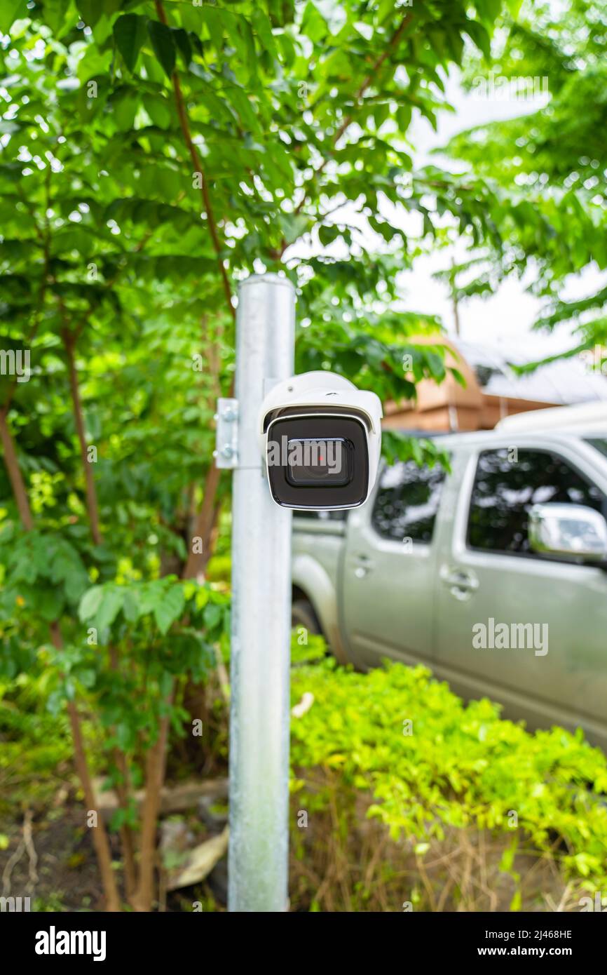 La telecamera CCTV è installata in giardino con sfondo verde sfocato per il controllo del monitor e del sistema di sicurezza intorno a quella zona. Foto Stock