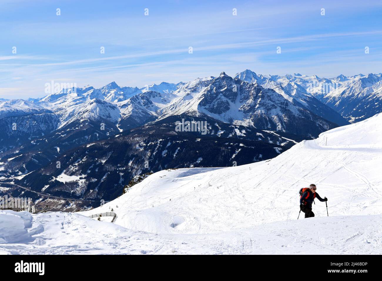 Una donna che indossa sci e racchette sale vicino alla cima del monte Patscherkofel nelle Alpi austriache. Foto Stock