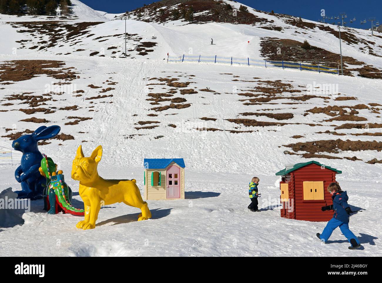 La colorata area giochi per bambini si trova nella stazione sciistica di Kühtai, nelle Alpi austriache, nei pressi di Innsbruck; gli sciatori sulle piste si trovano sullo sfondo Foto Stock