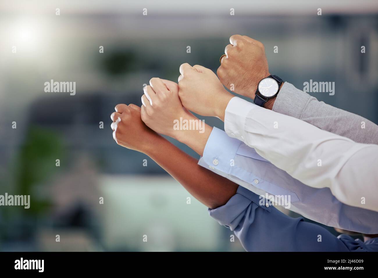 Siamo sempre insieme. Colpo di un gruppo di uomini d'affari irriconoscibili che tengono i loro pugni sul lavoro. Foto Stock
