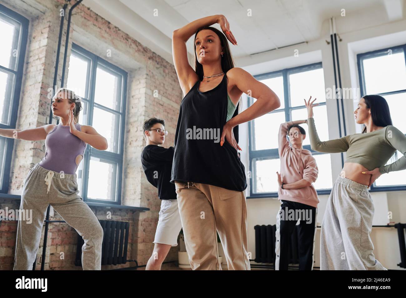 Artista femminile contemporaneo in abbigliamento sportivo che tiene il  braccio destro sopra la testa, mentre impara nuovi movimenti di danza del  voga Foto stock - Alamy