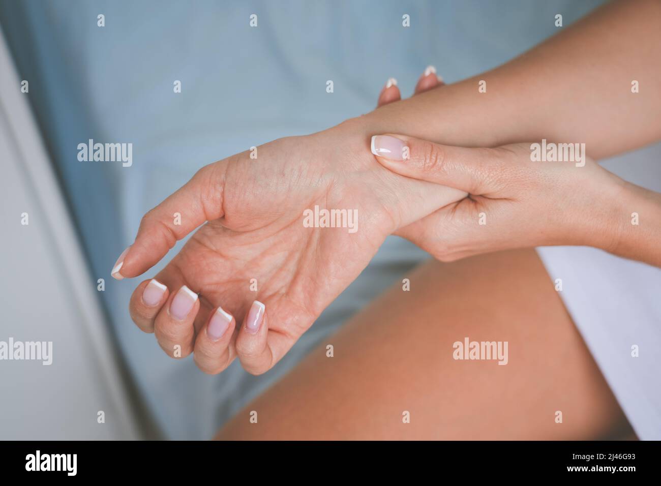 Donna che massaggiava polso o mano con sindrome del tunnel carpale e intorpidimento Foto Stock
