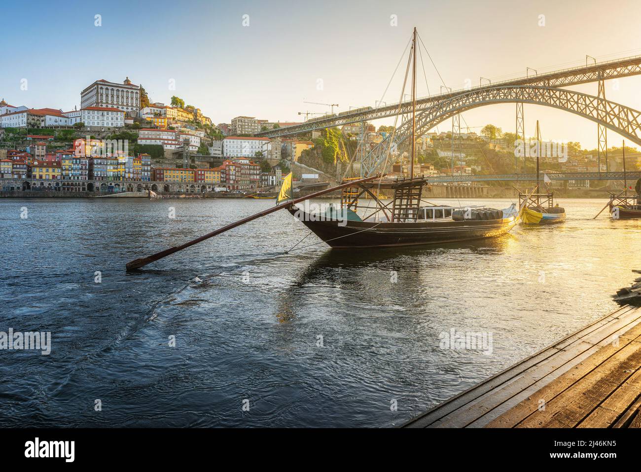 Porto, Portogallo. Vista all'alba di barche tradizionali rabelo con ponte Dom Luis sul fiume Douro con la città vecchia di Oporto città. Destinazione del viaggio Foto Stock