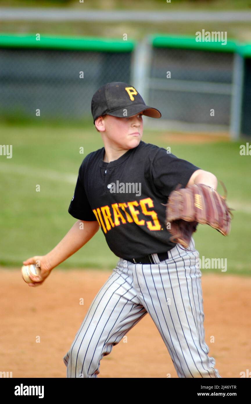 Ragazzi giovani che giocano a baseball su campo di palla, Pitcher, Catcher, Hitter e Coach Foto Stock