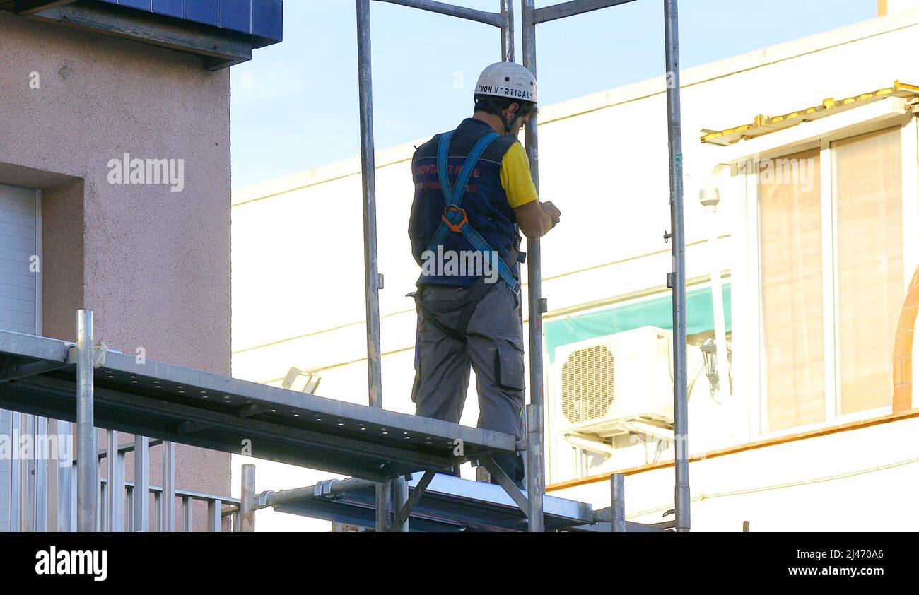 Operaio che lavora alla ristrutturazione della facciata di un edificio a Barcellona, Catalogna, Spagna ed Europa Foto Stock