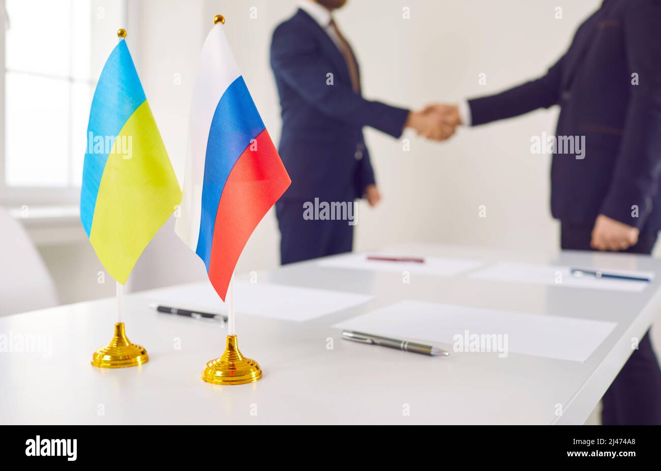 I rappresentanti della Russia e dell'Ucraina si scuotono le mani dopo aver negoziato un accordo pacifico Foto Stock