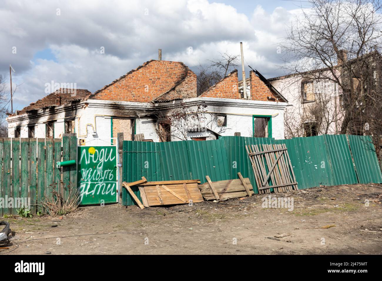 ANDRIIVKA, UCRAINA - 12 aprile 2022: Caos e devastazione per le strade di Andriivka a seguito dell'attacco degli invasori russi. L'iscrizione sulla porta - la gente vive, i bambini Foto Stock