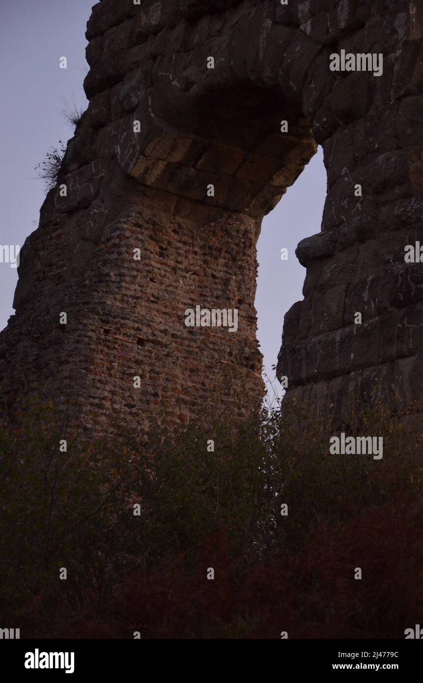 Foto scattate al tramonto durante una passeggiata attraverso il bellissimo Parco degli acquedotti di Roma, con le maestose rovine di antichi acquedotti e alberi romani Foto Stock