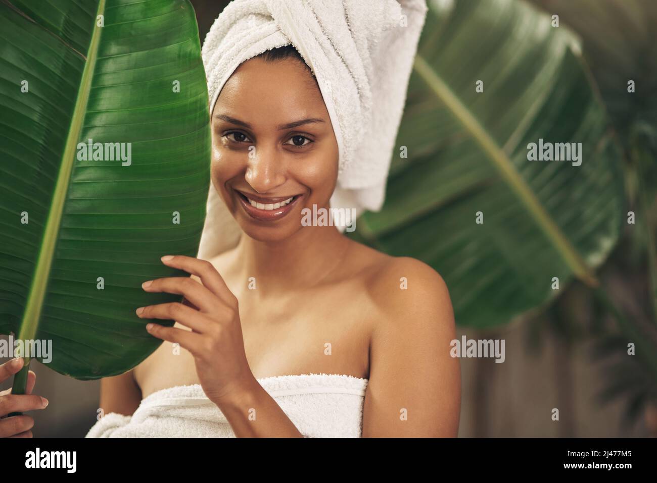 Non si rivolgono a prodotti tossici quando la natura ha tutte le soluzioni. Shot di una bella giovane donna che indossa un asciugamano intorno alla testa mentre si posa dietro un Foto Stock