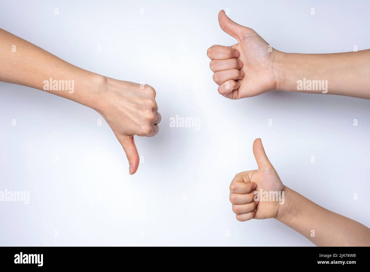 le mani mostrano i pollici su e giù su uno sfondo bianco Foto Stock