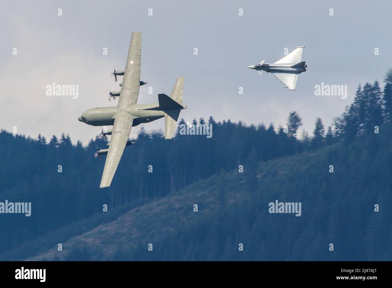 Aviazione militare austriaca Eurofighter jet intercettare un aereo da trasporto C-130 Hercules in una missione di addestramento Foto Stock