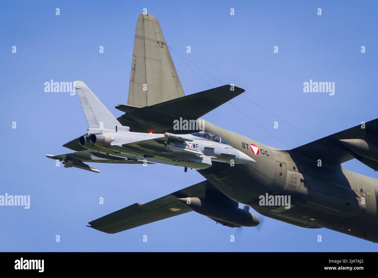 Aviazione militare austriaca Eurofighter jet intercettare un aereo da trasporto C-130 Hercules in una missione di addestramento Foto Stock