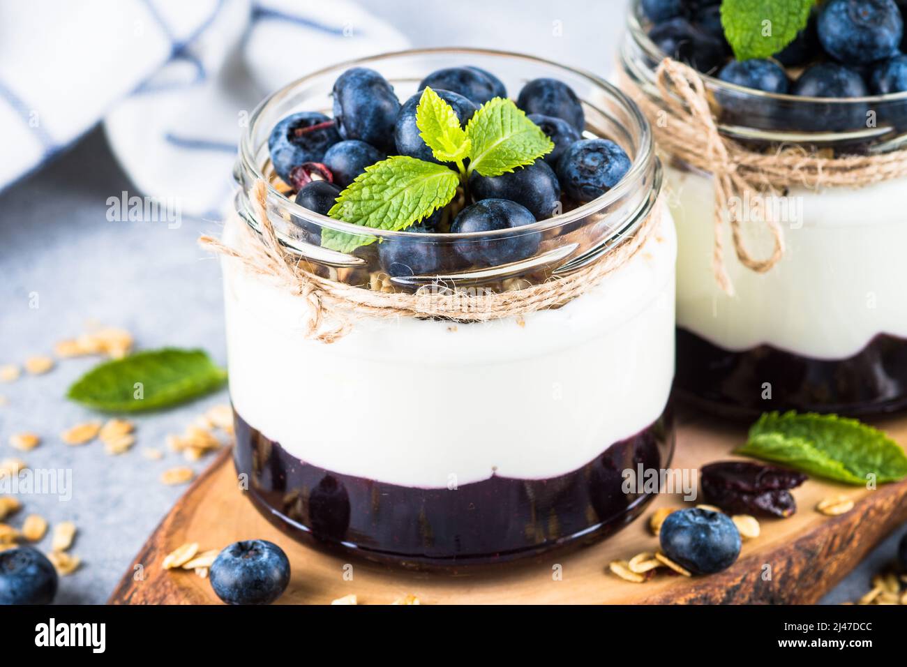 Parfait con mirtillo, granola e marmellata in due vasetti di vetro. Foto Stock