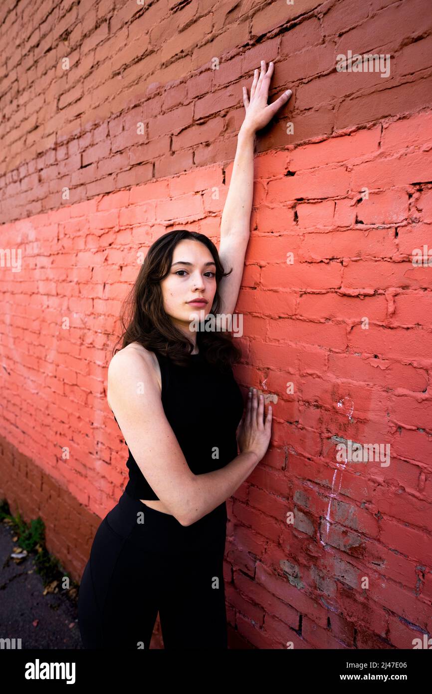 Teenage Female Dancer Standing by Painted Brick Building in Downtown Berkeley Foto Stock