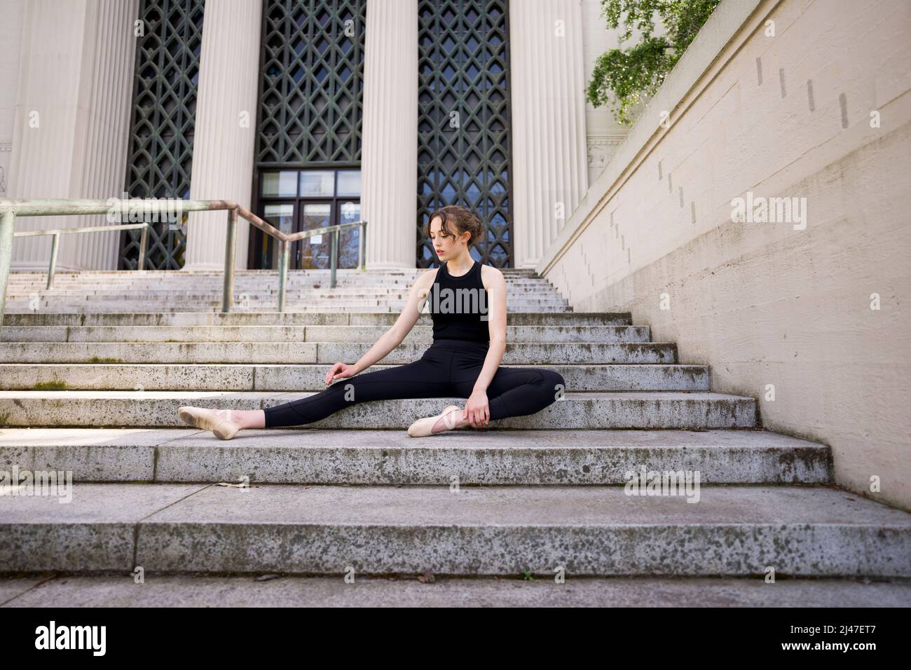 Teenage Dancer femminile che si estende su Berkeley Psychology Building Scale Foto Stock