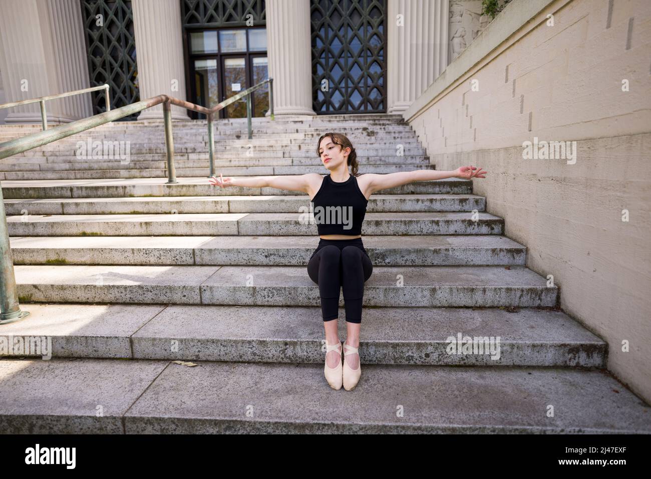 Teenage Dancer femminile che si estende su Berkeley Psychology Building Scale Foto Stock