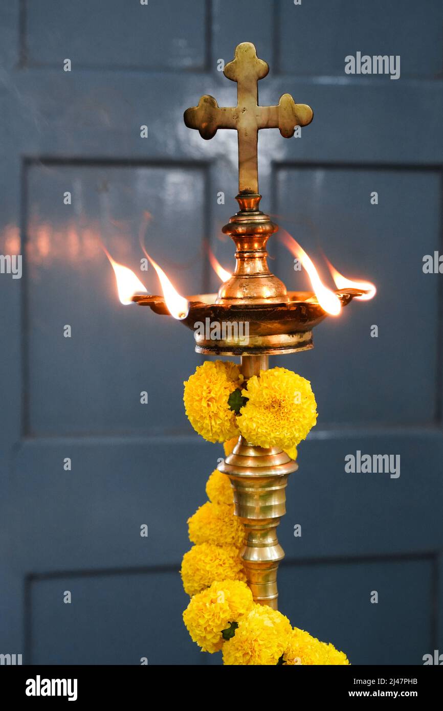 Lampada ad olio divina con ghirlande di fiori e croce, diocesi cattolica di Baruipur, India Foto Stock