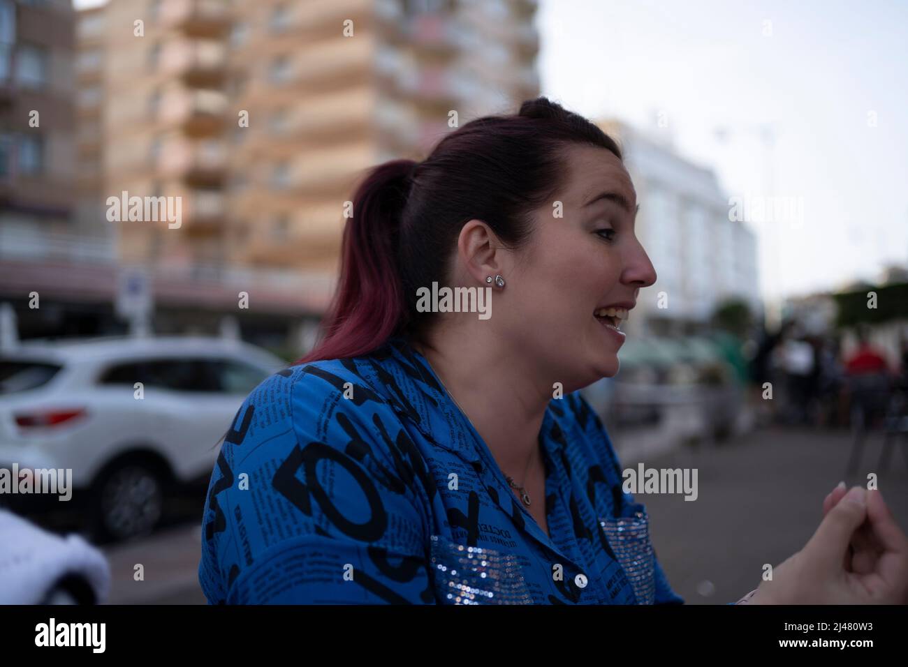 donna d'affari che parla per strada, gesturando quando parla Foto Stock