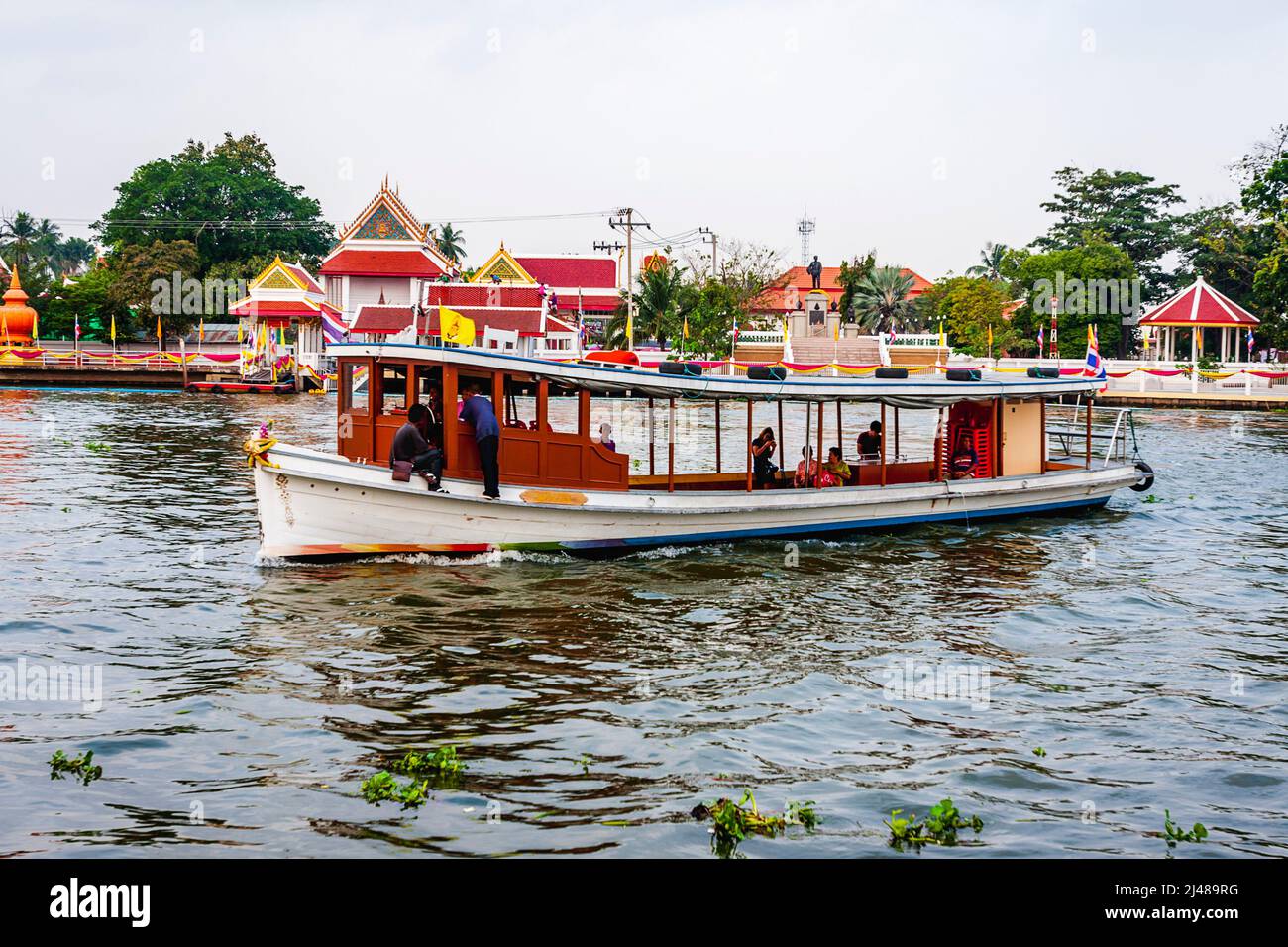 Una piccola barca passeggeri trasporta le persone avanti e indietro attraverso il fiume al tempio buddista. Foto Stock