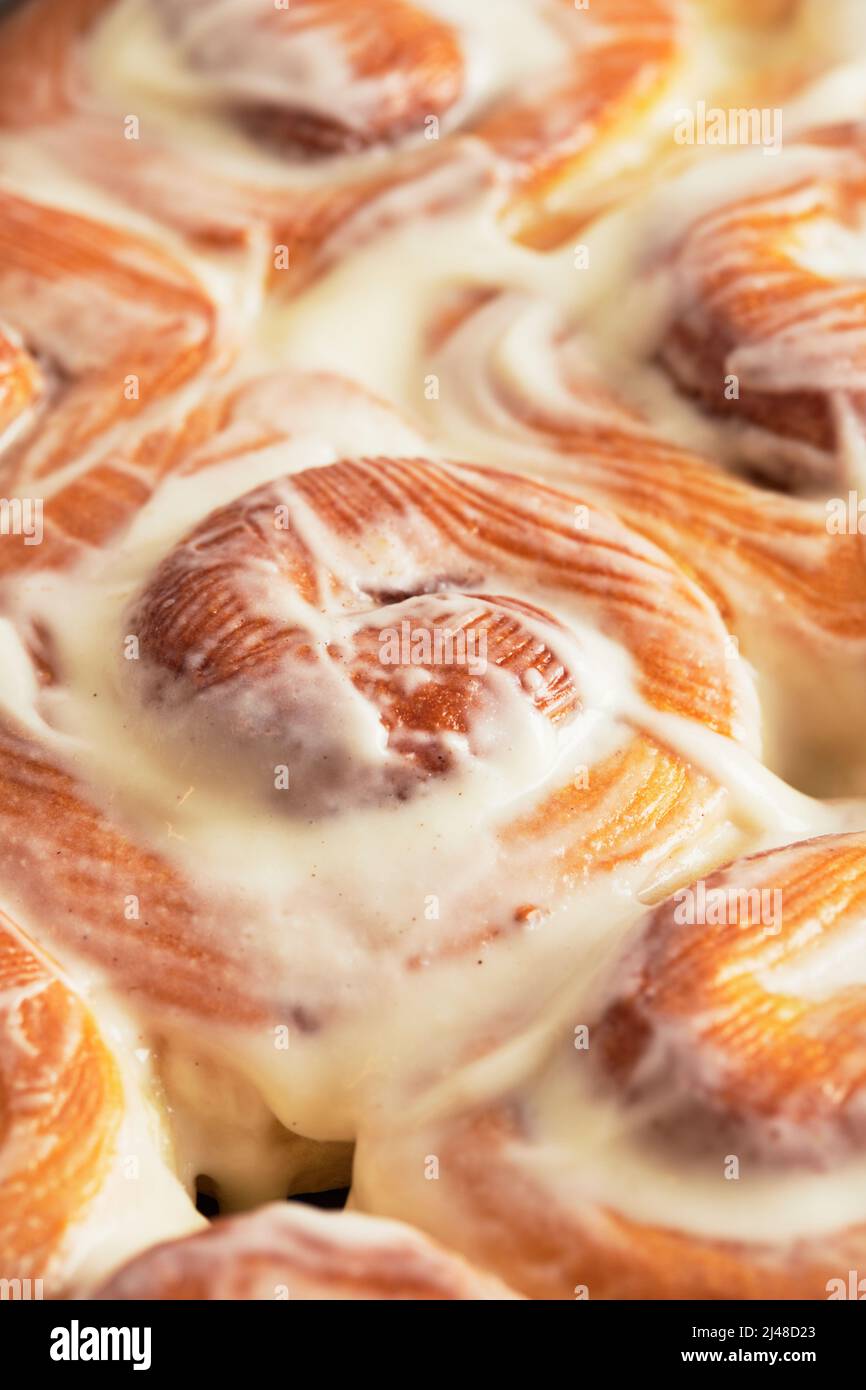 I cinaboni fatti in casa in una teglia da forno vengono prelevati dal forno. Vista frontale. Foto Stock