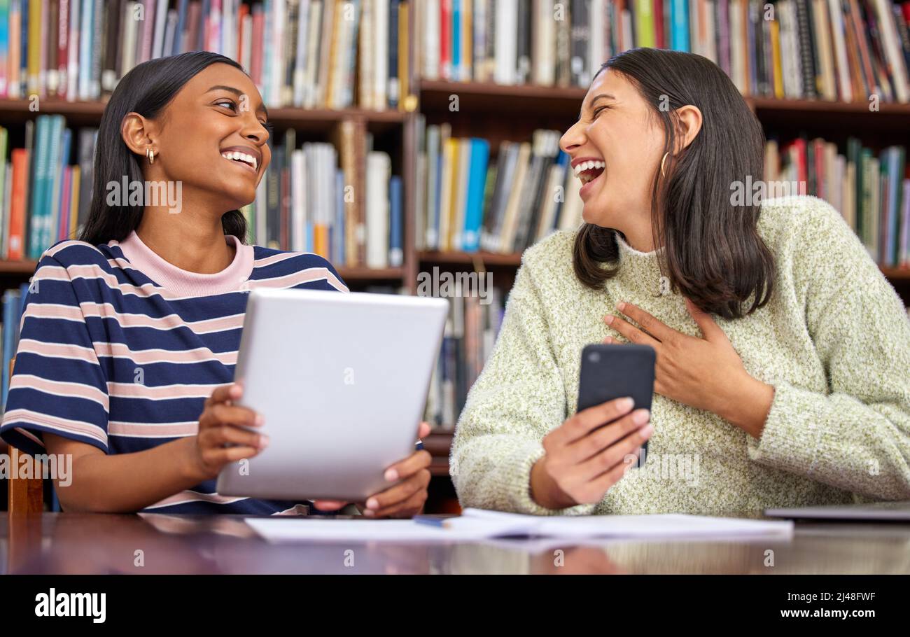 Rendere ogni giorno un po 'meglio di prima. Scatto di due femmine utilizzando i loro dispositivi in una libreria. Foto Stock