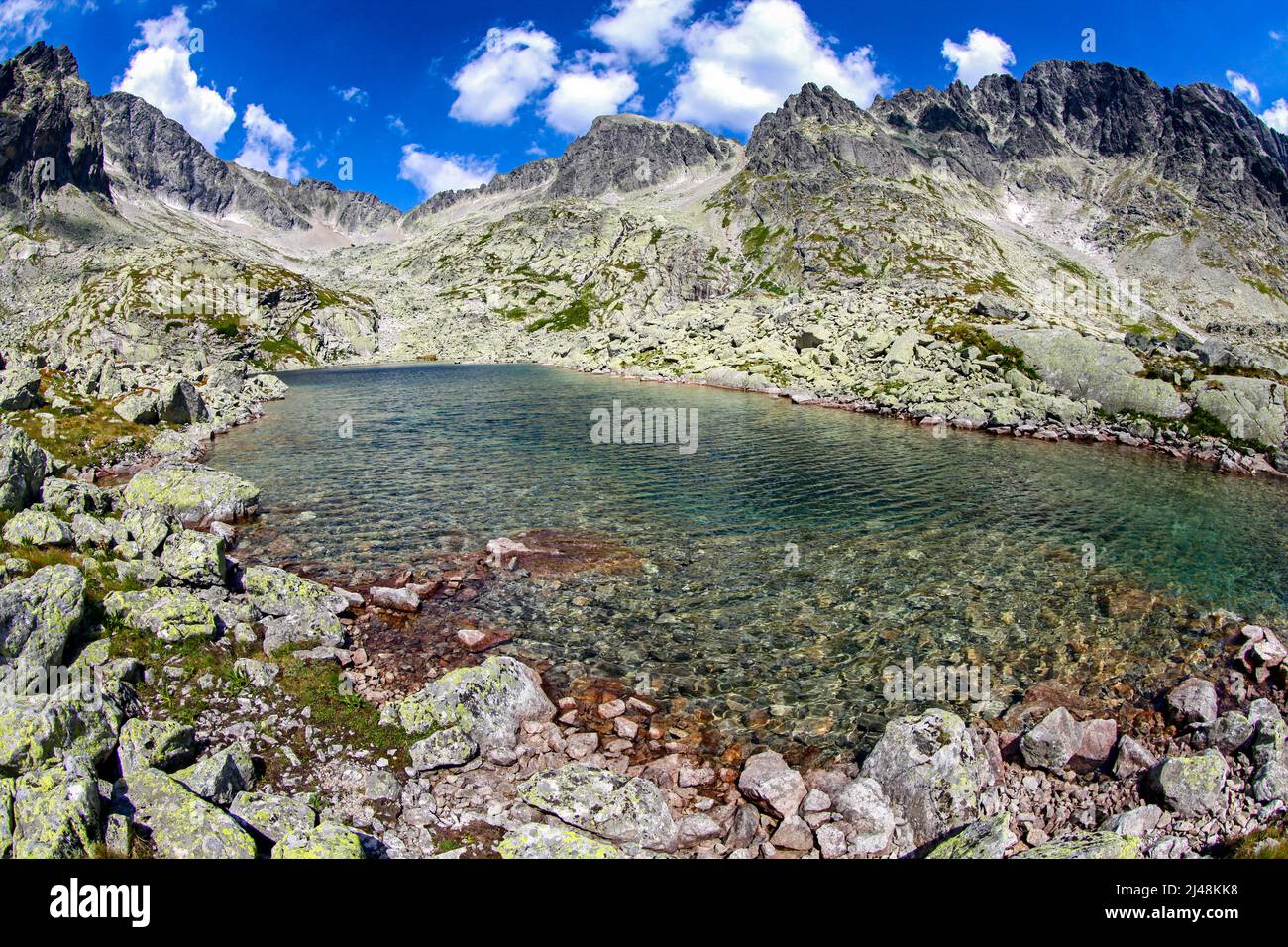 Bella giornata estiva in montagna. Lago e picchi sullo sfondo. Cinque strati di Spisskich - Tarn in alti Tatra montagne in Slovacchia Foto Stock