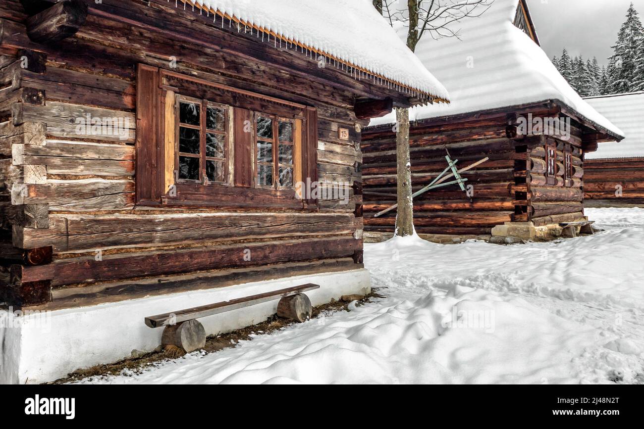 Cottage rurale in legno nel villaggio nevoso in inverno. Museo all'aperto a Zuberec, Slovacchia Foto Stock