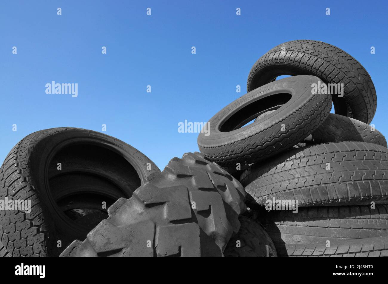 Vecchi pneumatici contro un cielo blu Foto Stock